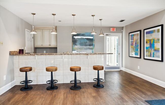 a kitchen with a bar and stools in a living room