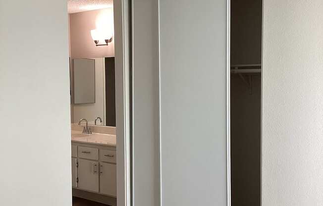 A bathroom with a sink, mirror, and cabinets.