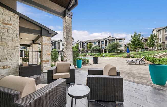 A patio with a table and chairs is surrounded by apartment buildings.