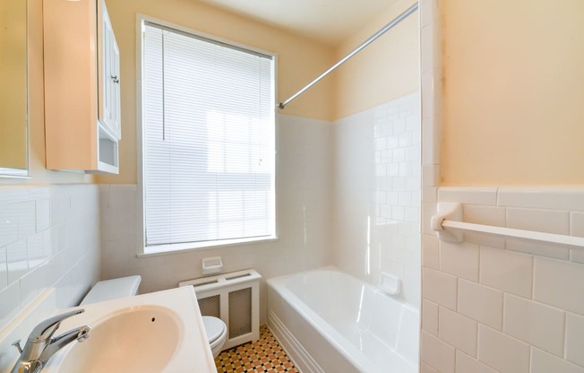 bathroom with vanity toilet, tub, and large window  at 1401 sheridan apartments in washington dc