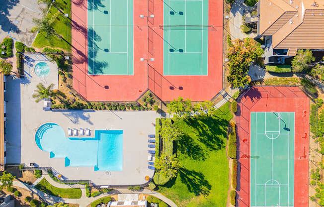 An aerial view of a tennis court and a swimming pool.