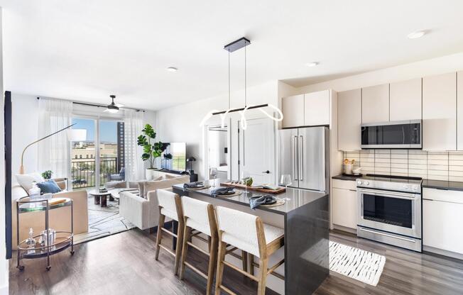 This open-concept layout features a spacious waterfall island perfect for dining or prep, with cabinetry available in multiple designer-selected finish options.