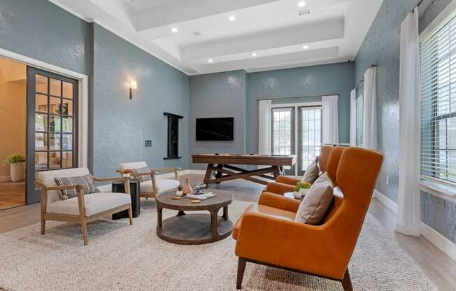 a living room with blue walls and an orange couch at Summerwind, Texas, 77584