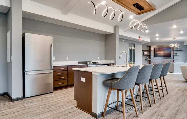 a kitchen with a island and chairs in front of a refrigerator. Circle Pines, MN Lexington Lofts