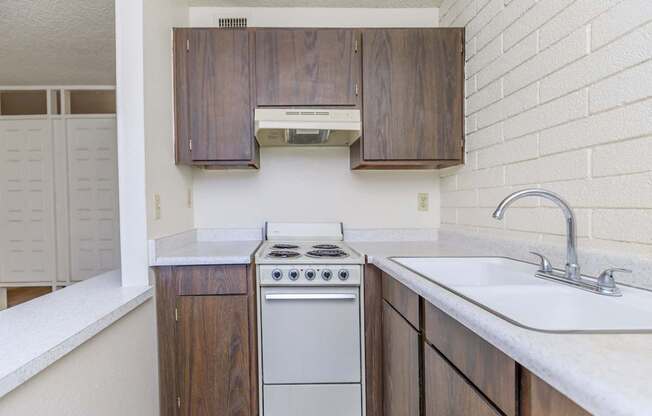 A kitchen with a white counter top and a white sink.