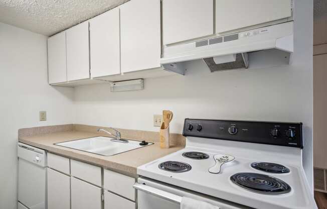 a kitchen with a stove top oven and a sink