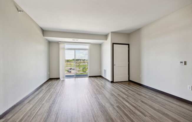 an empty living room with white walls and wood floors