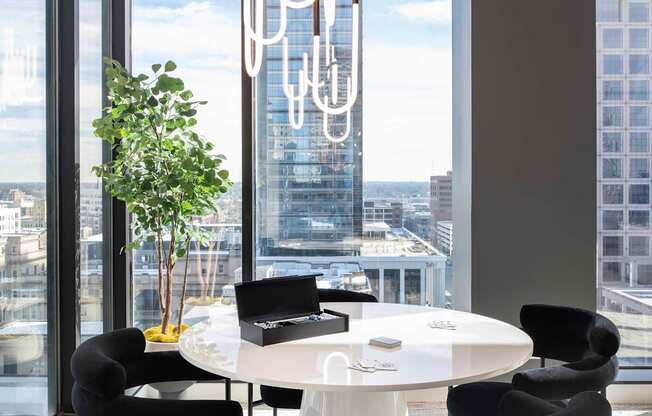 a round white table with black chairs in a room with floor to ceiling windows  at 220 Meridian, Indianapolis, IN, 46204