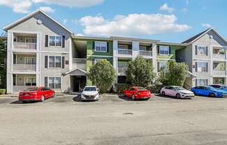 A row of cars parked in front of apartment buildings.