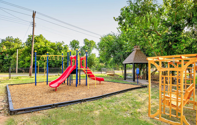 a playground at a park with a red slide