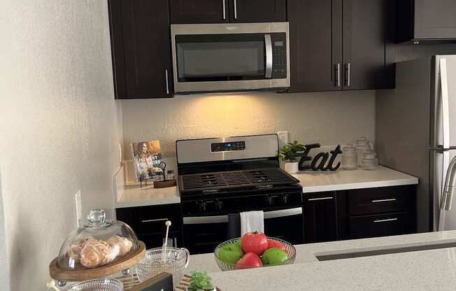 a kitchen with black cabinets and a counter with food on it