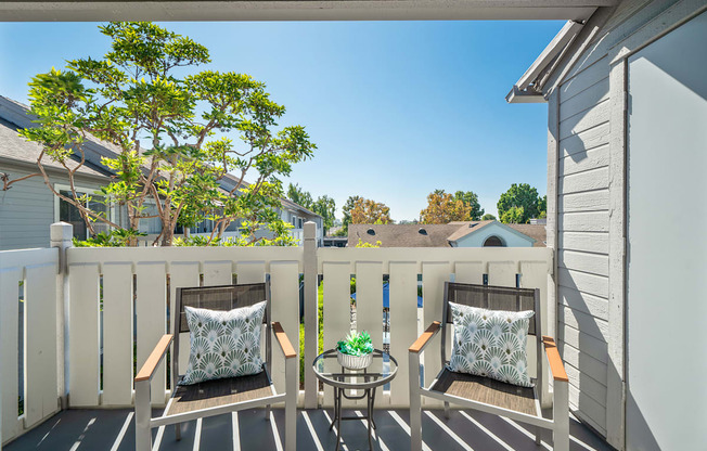 a balcony with two chairs and a table