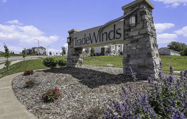 entrance sign with landscaped flowers at Trade Winds Apartment Homes in Elkhorn, NE 68022