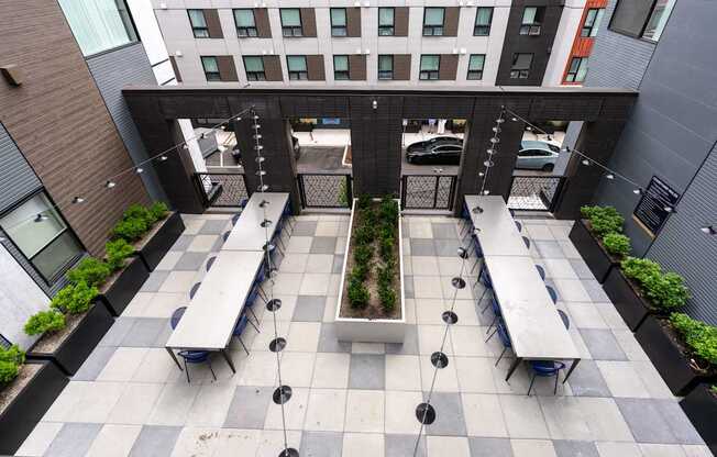 A courtyard with benches and a planter in the middle.