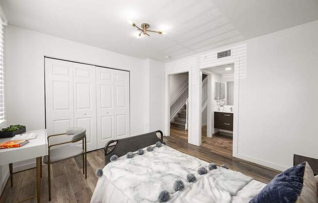 a bedroom with a large bed and a desk with a chair