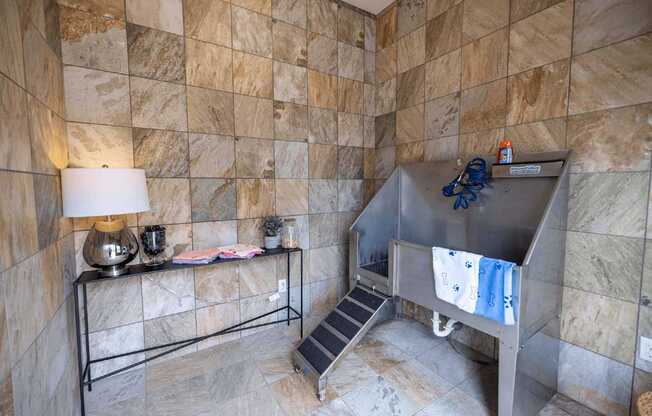 A bathroom with a tiled wall and a metal staircase.
