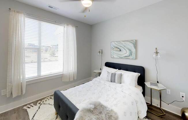 a bedroom with a bed and a large window at Echo Park at Perry Crossing Apartments, Plainfield, IN, 46168