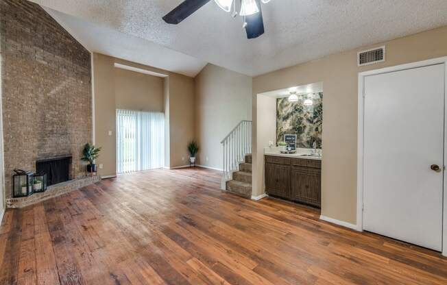 an empty living room with a fireplace and wooden floors