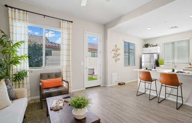 a living room with a dining area and a kitchen with a table and chairs