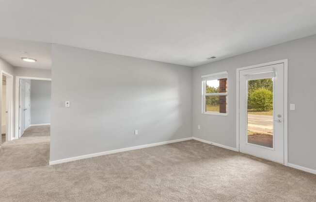 a living room with white walls and a carpeted floor