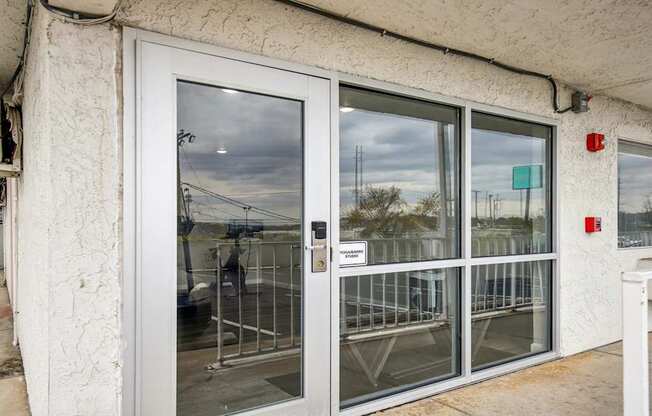 A white door with a glass window and a metal grill.