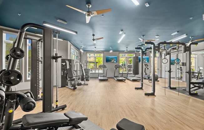 A gym with a variety of equipment including treadmills, weights, and exercise machines.