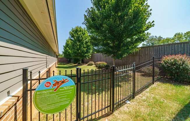 a yard with a fence with a sign on it