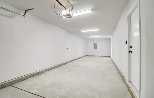 A long, empty hallway with a white door on the right.
