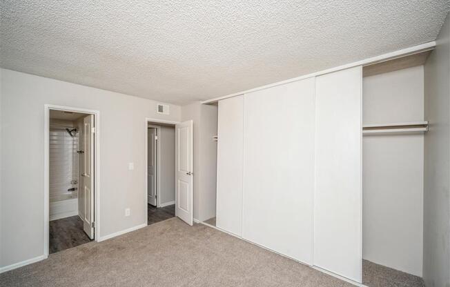 Bedroom with white walls and closet doors  at Avery Park in Englewood, CO