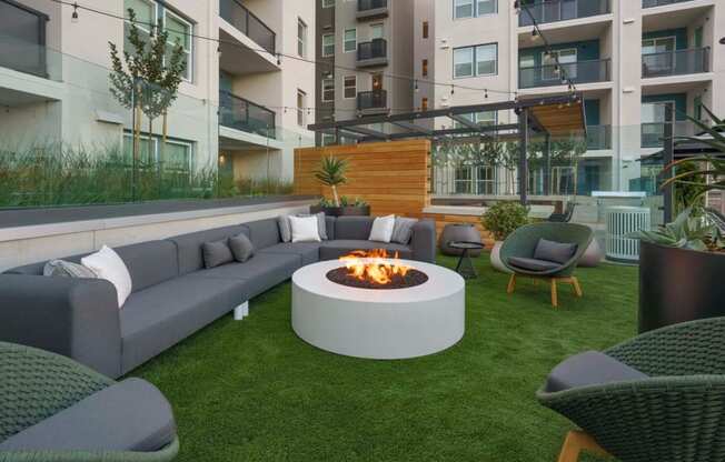 Outdoor Community Lounge With Firepit, Chairs, Tables, And Maintained Landscaping In the Heart Of The Apartment Building. at NoMa Apartments, Walnut Creek, 94596