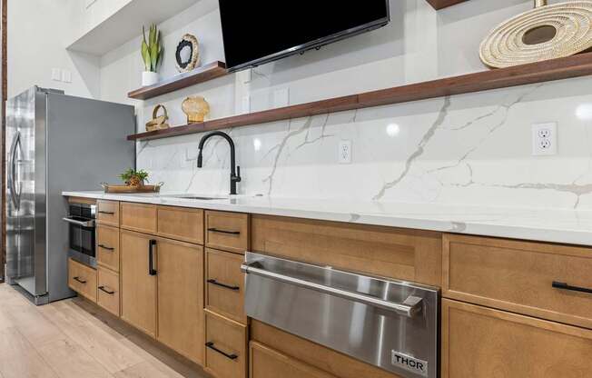A kitchen with a marble countertop and wooden cabinets.