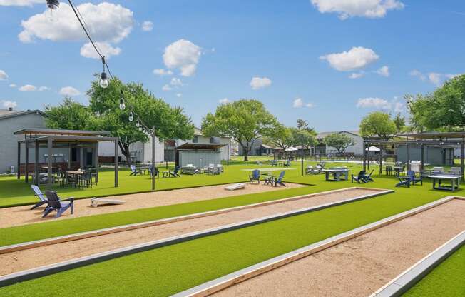a rendering of a park with grass and tables and chairs