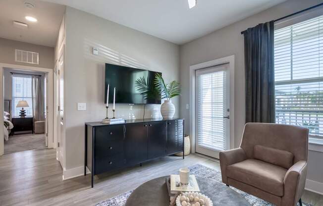 A living room with a brown chair and a black cabinet.