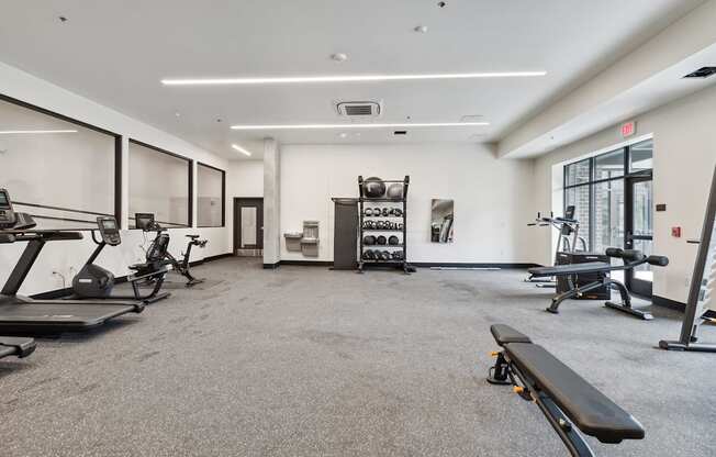 A spacious gym with a variety of equipment including treadmills, exercise bikes, and weight racks.