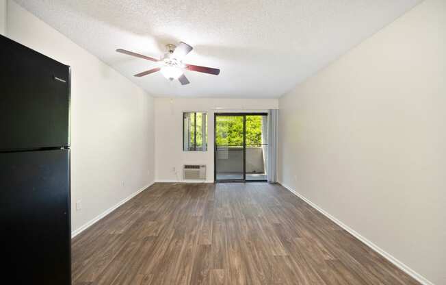 a studio apartment living space with sliding glass door and window