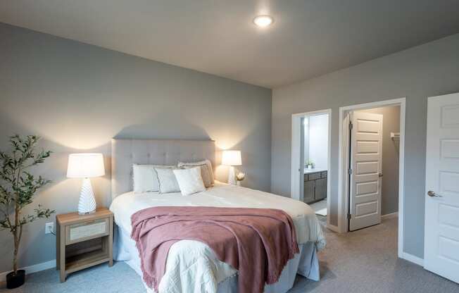 a bedroom with a large bed and a door to a bathroom