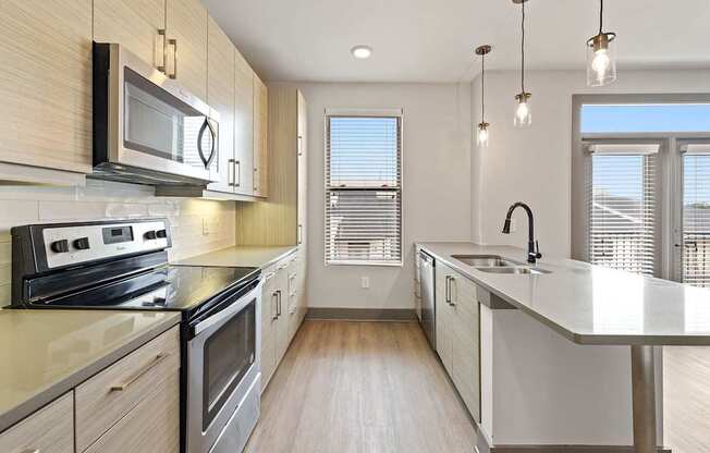 A modern kitchen with stainless steel appliances and wooden cabinets.
