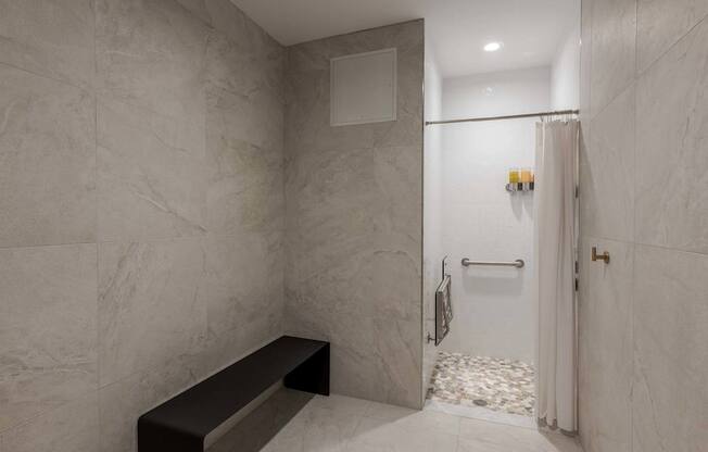 A bathroom with a marble wall and a bench.