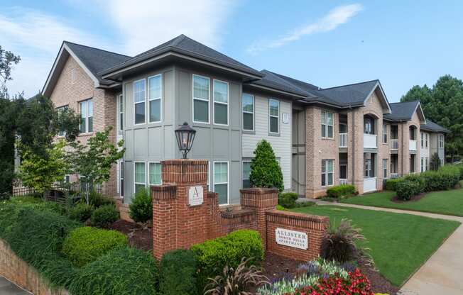 an apartment building with a lawn and a sidewalk in front of it
