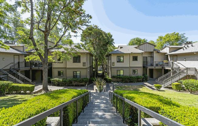 the view of an apartment complex with stairs and lawns