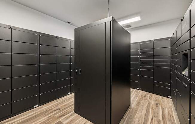 A room with black lockers and a wooden floor.