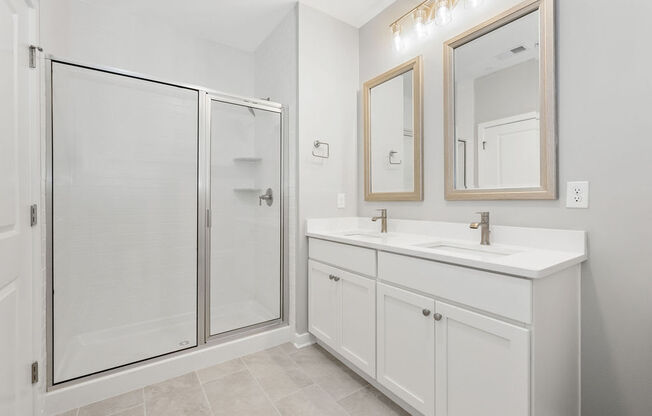 A white bathroom with a walk-in shower and double sink vanity at Madison Prickett Preserve, Pennsylvania