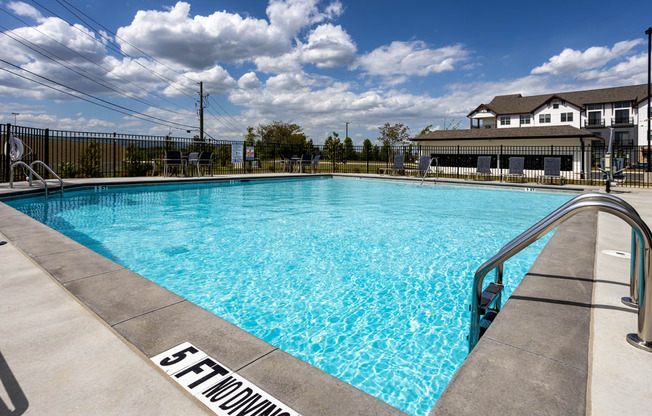 a swimming pool with a house in the background