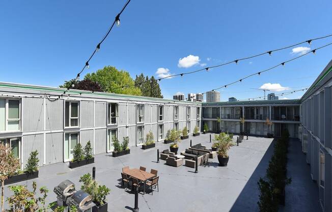 a courtyard with seating and plants on a sunny day at Cosmopolitan, Seattle