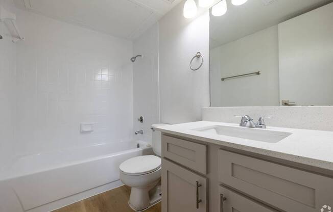 A white toilet sits in a bathroom next to a sink.