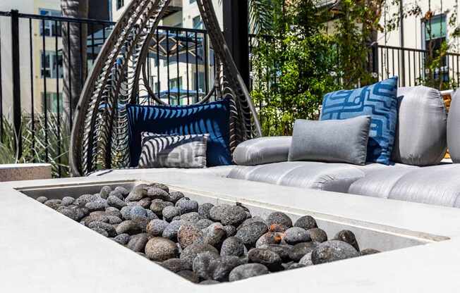 A modern outdoor seating area with a rock garden and a metal chair.