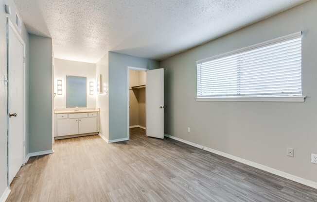an empty living room with a bathroom and a window