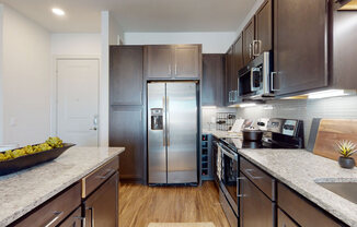 a kitchen with dark wood cabinets and stainless steel appliances