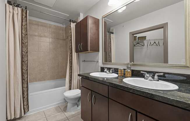 a bathroom with two sinks and a shower and a toilet