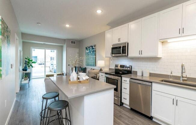 A kitchen with white cabinets and a large island.